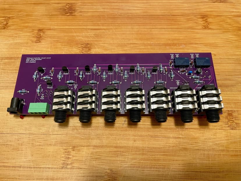 a purple circuit board is sitting on top of a wooden table .