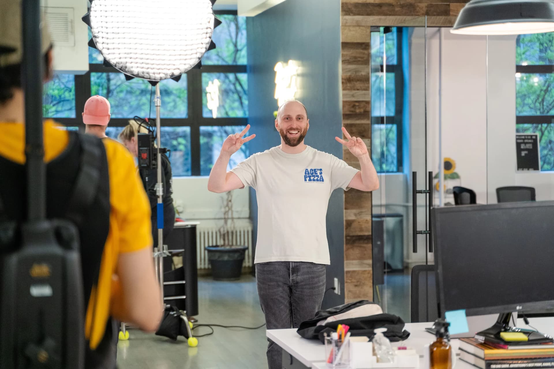 a man is standing in front of a camera in an office .