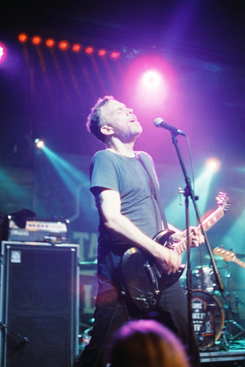 a man singing into a microphone while playing a guitar