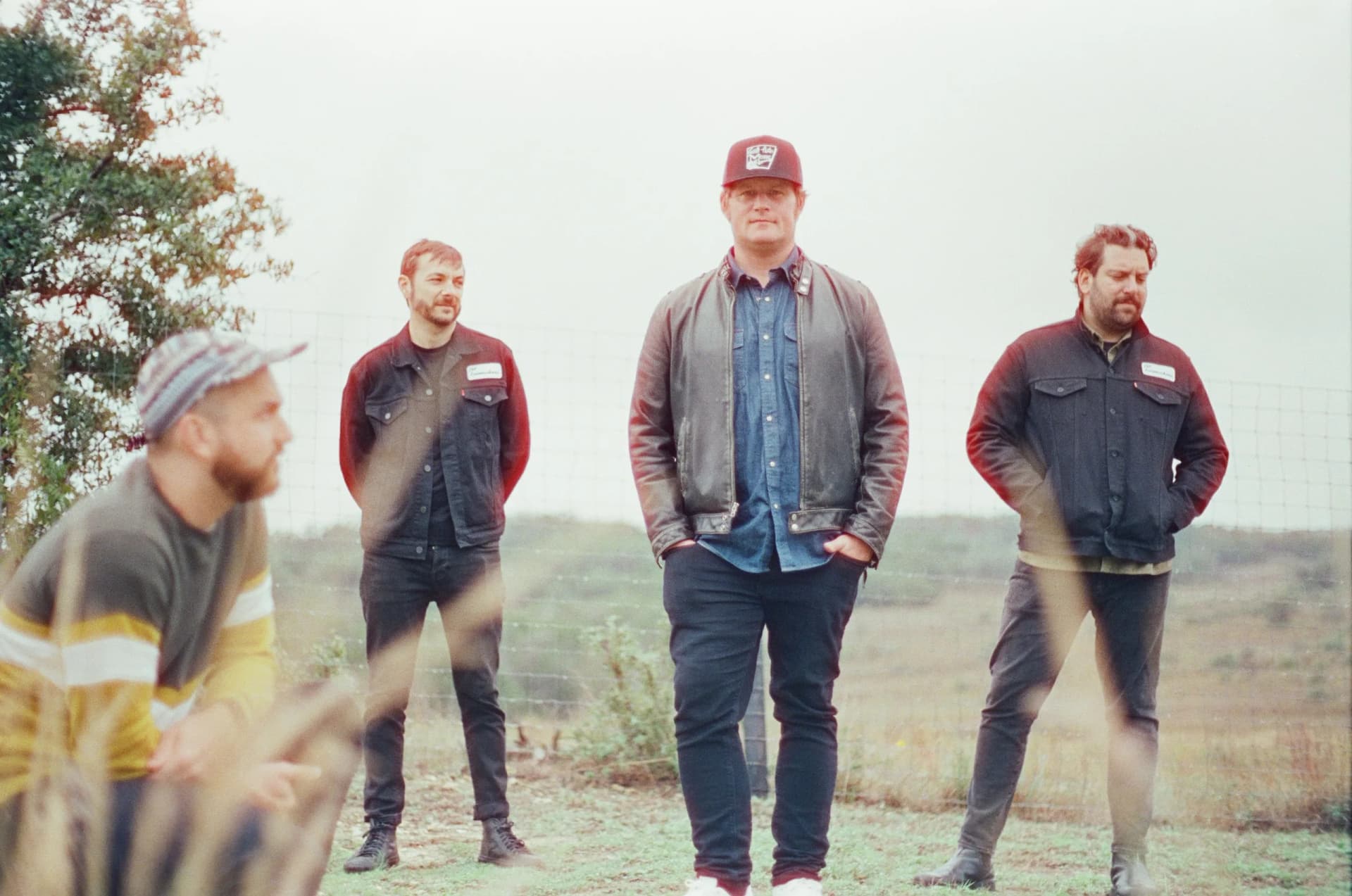 the loveshakers are standing next to each other in a field .