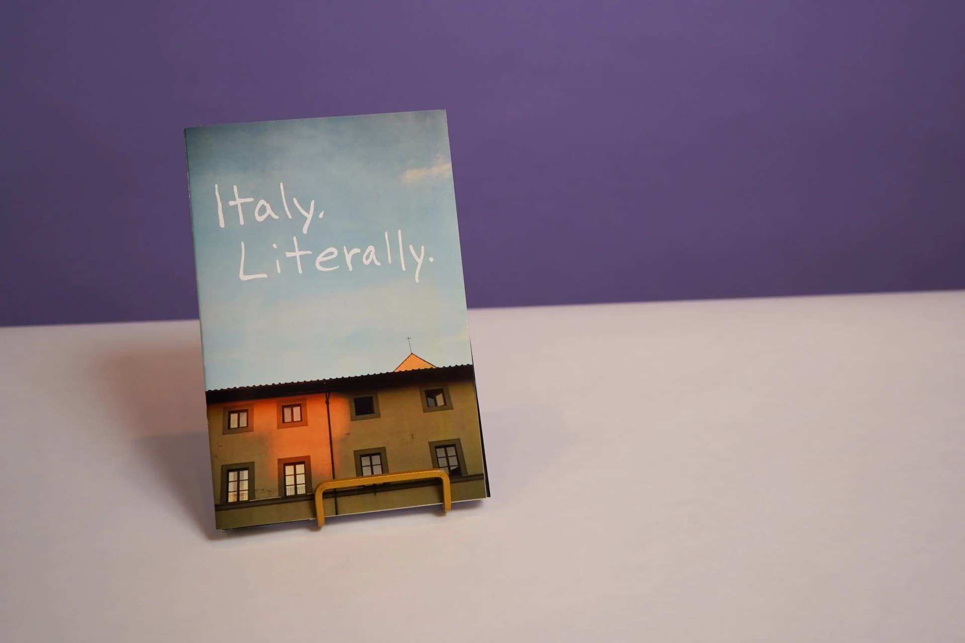 a zine titled italy literally is sitting on a table .