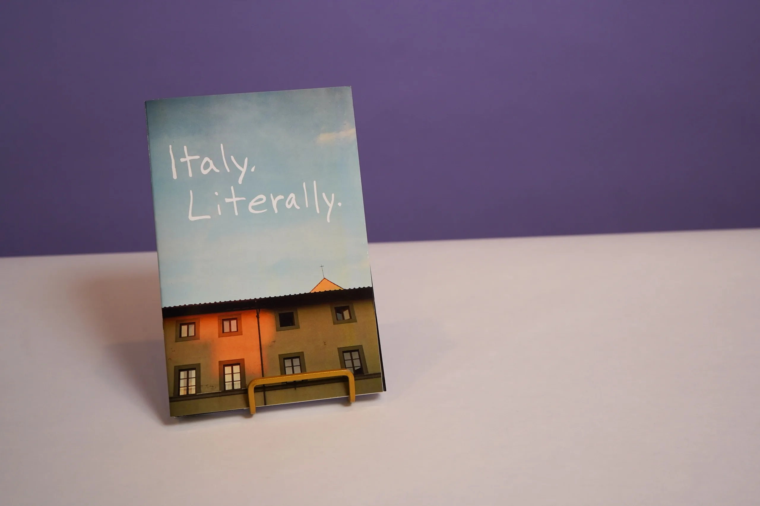 a zine titled italy literally is sitting on a table .