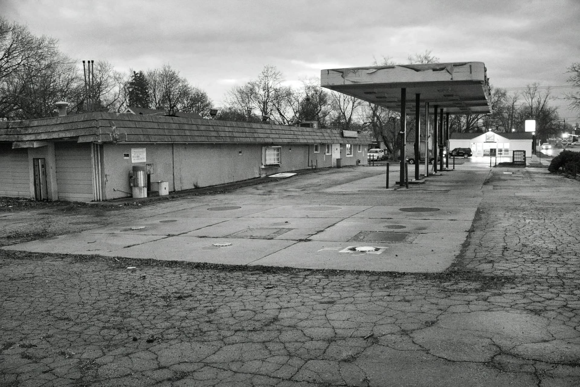 a black and white photo of an abandoned gas station .