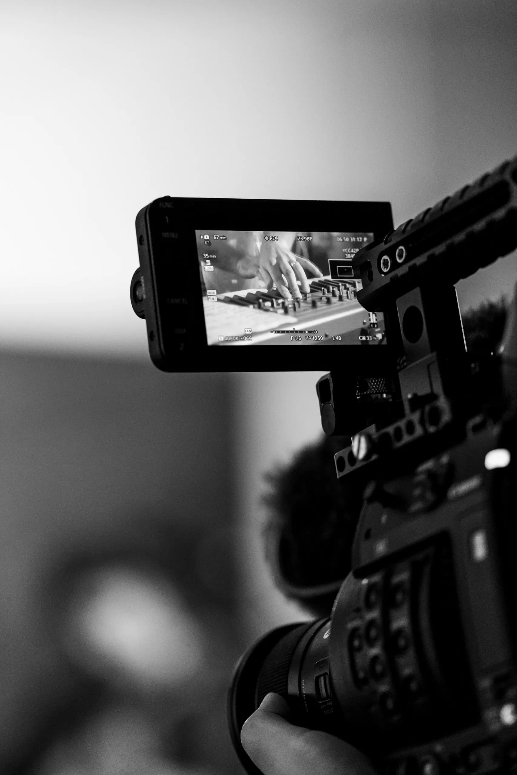a black and white photo of a person using a video camera