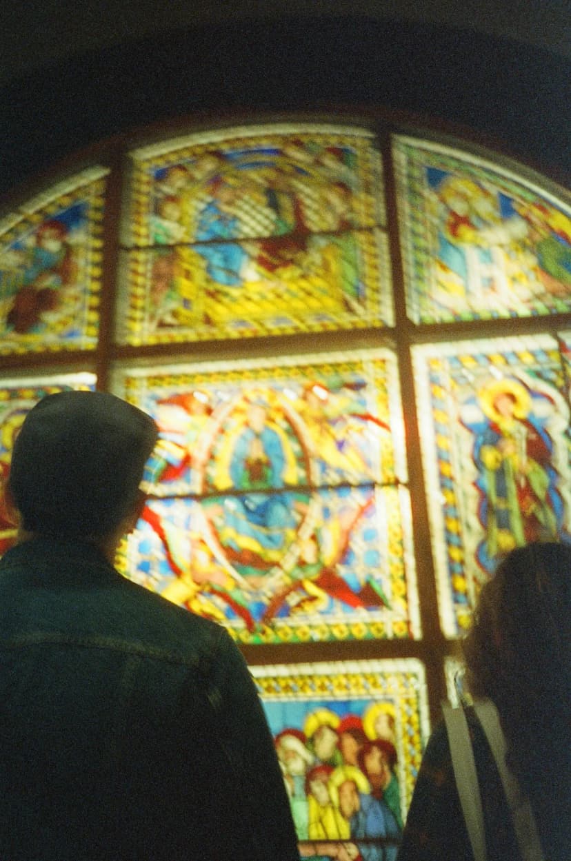 two people are looking at a stained glass window