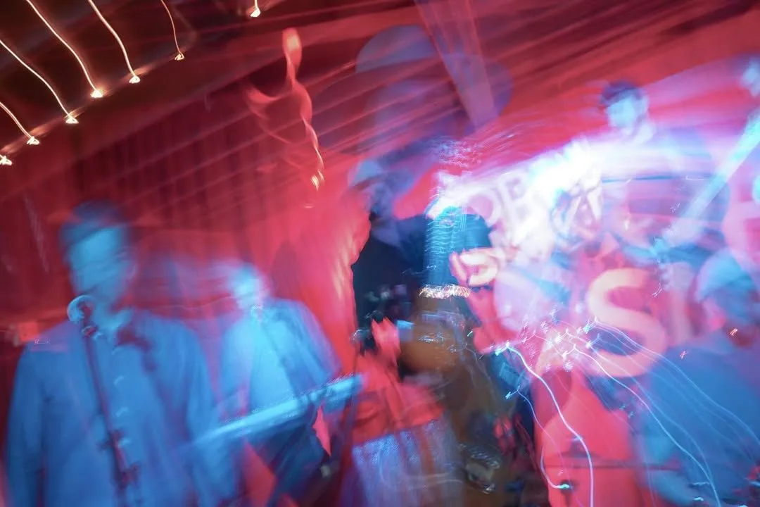 a blurry picture of a group of people playing instruments on a stage .