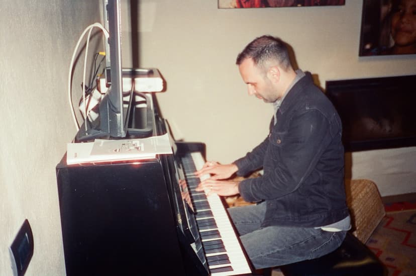 a man is playing a piano in a living room .