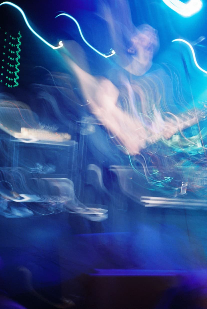 a blurry picture of a person playing a guitar in a dark room