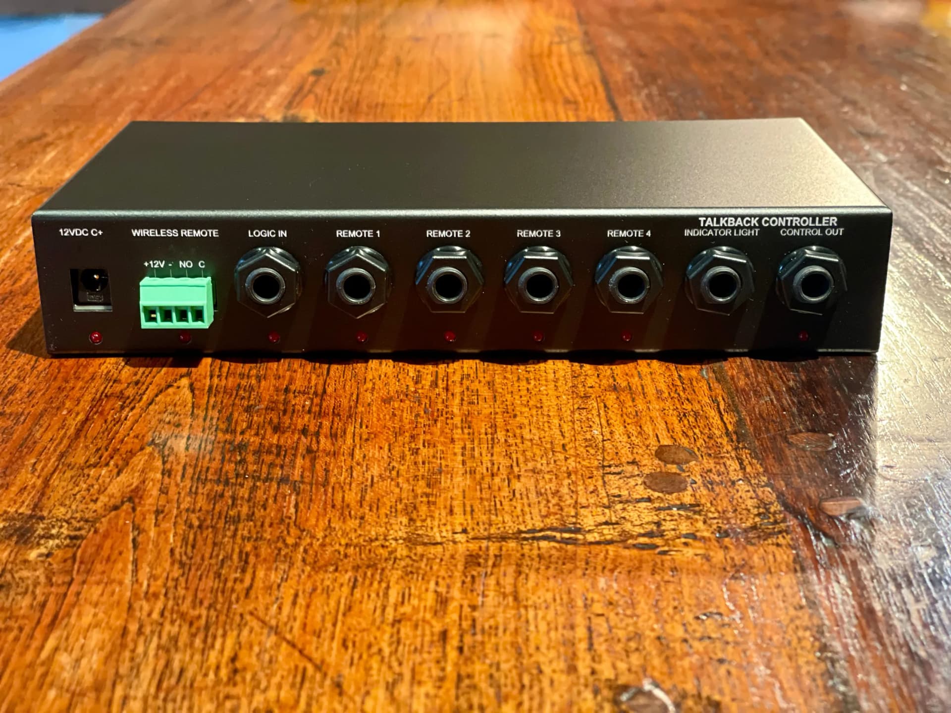 a black electronic box is sitting on top of a wooden table .