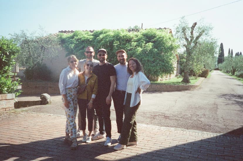a group of people are posing for a picture in front of a building .