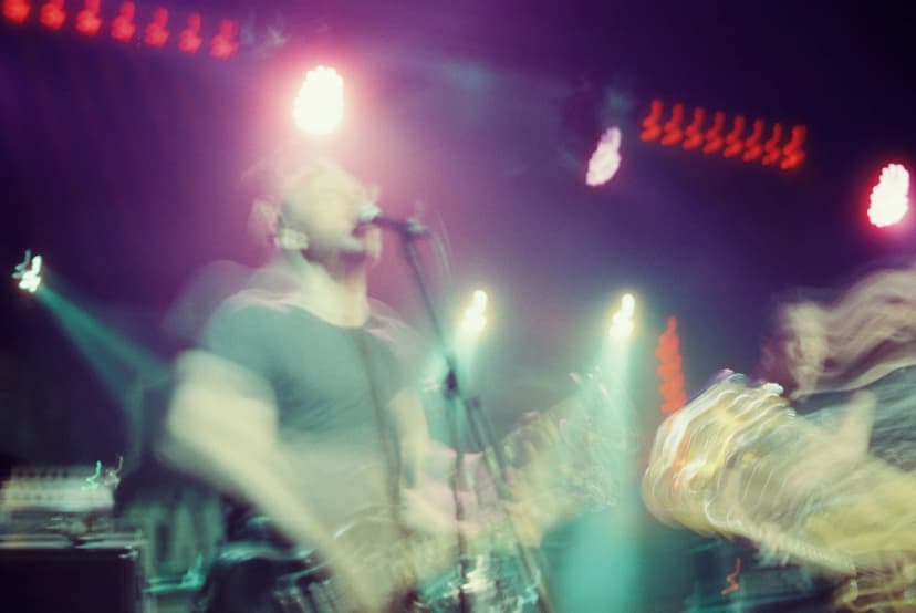 a man is playing a guitar and singing into a microphone on a stage .