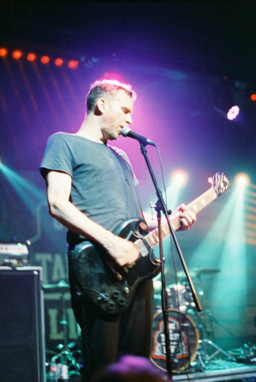a man singing into a microphone while playing a guitar